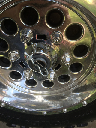 Pull the pin and the wheel comes right off. The lug nuts are fake, sorry.